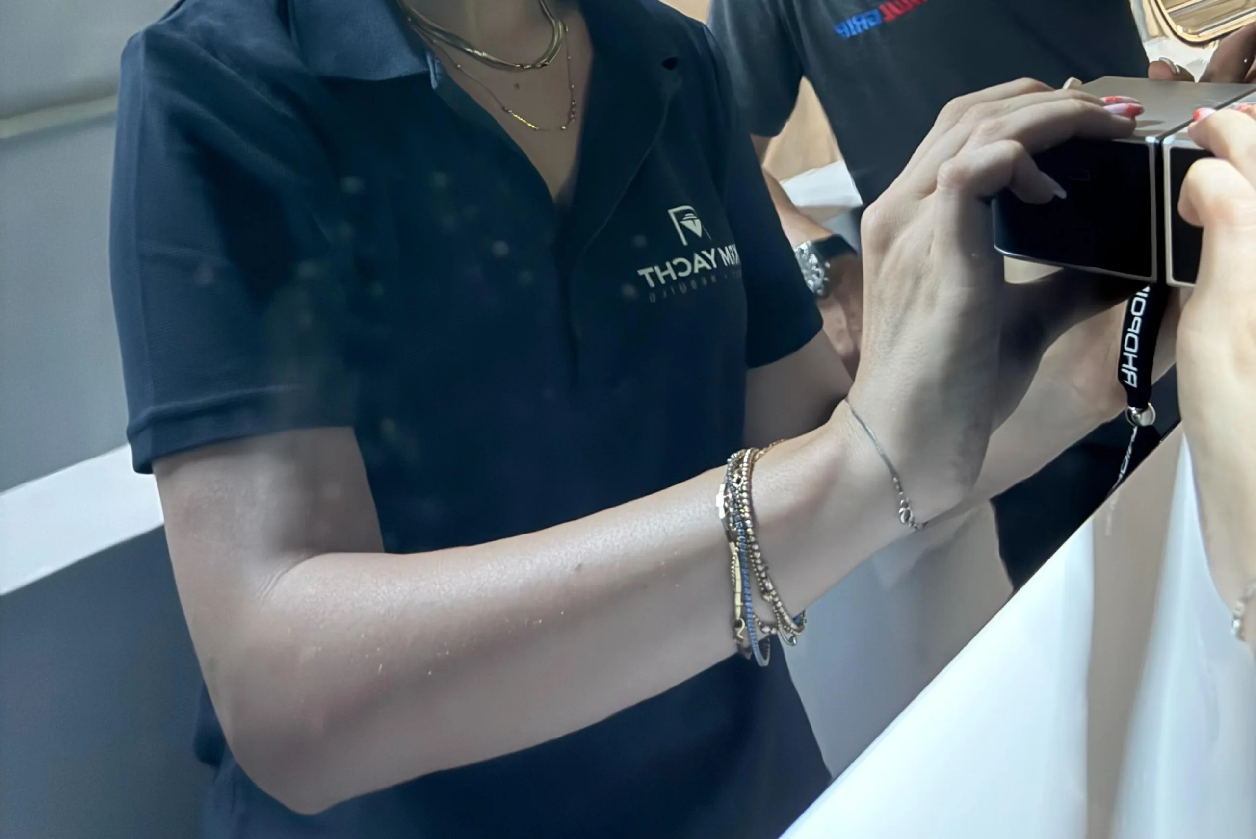 TECHNICIAN MEASURES GLOSS/FINISH QUALITY ON A YACHT TOPCOAT USING A HANDHELD INSPECTION METER.